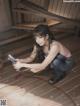 A woman kneeling down with a drill in her hand.