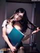 A woman in a white shirt and black stockings holding a blue book.
