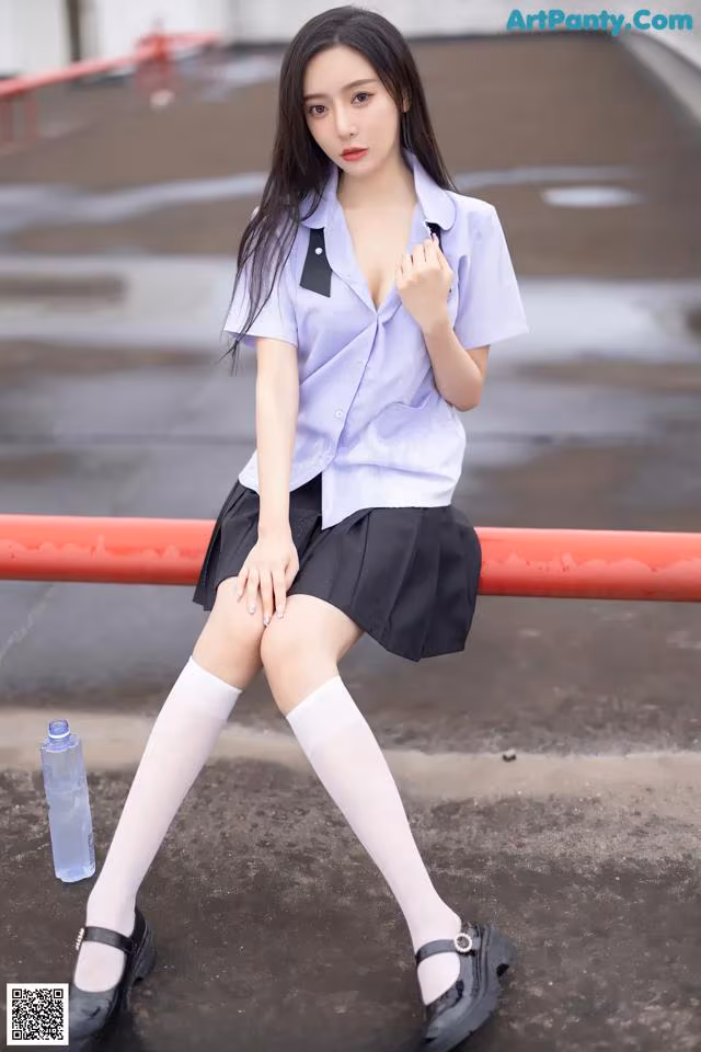 A woman in a school uniform is posing for a picture.