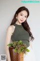 A woman holding a basket with a plant in it.