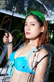 A woman in a blue bikini holding an umbrella.