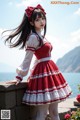 A woman in a red and white dress posing for a picture.