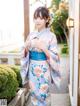 A woman in a blue and pink kimono posing for the camera.