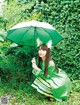 A woman in a green dress holding an umbrella.