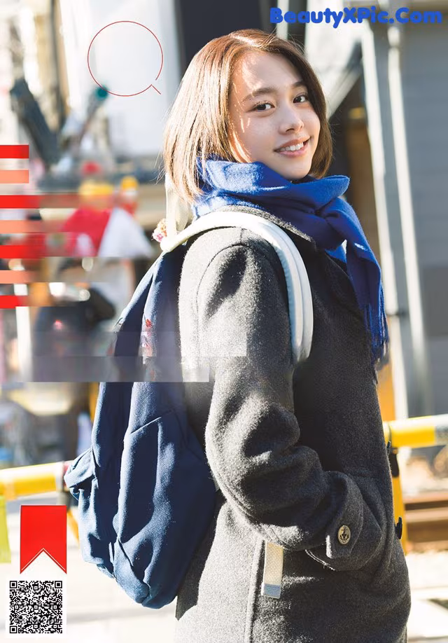 A woman with a backpack standing in front of a building.
