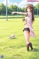 A girl in a pink shirt and black skirt standing in a field with a white dog.