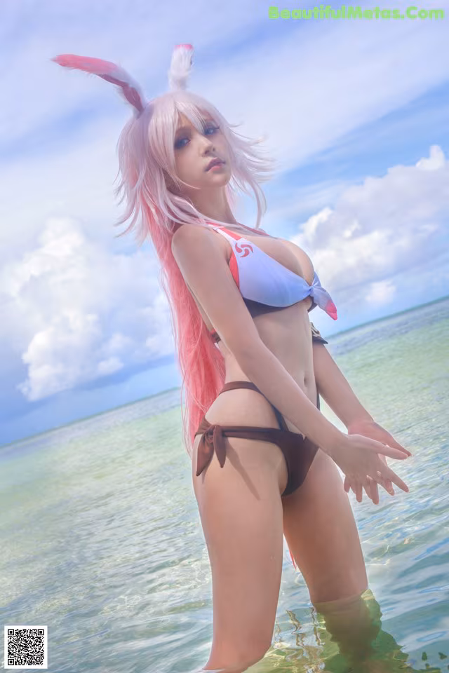 A woman in a bikini standing in the water.