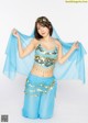 A woman in a blue belly dance outfit posing for a picture.