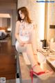 A woman sitting on a counter in a hotel room.