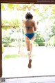 A woman in a blue bikini running out of a door.