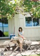 A woman in a bikini sitting at a picnic table.