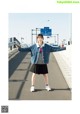 A woman standing on a bridge with her arms outstretched.